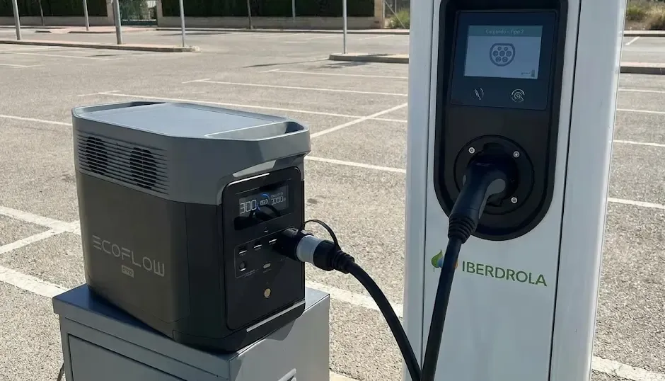 Estación de energía portátil conectada a un punto de recarga de coche eléctrico público mediante adaptador